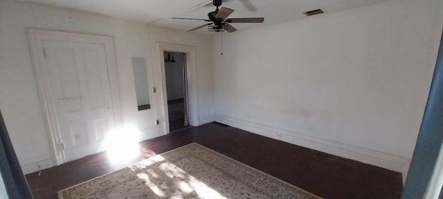 empty room featuring dark wood-type flooring and ceiling fan