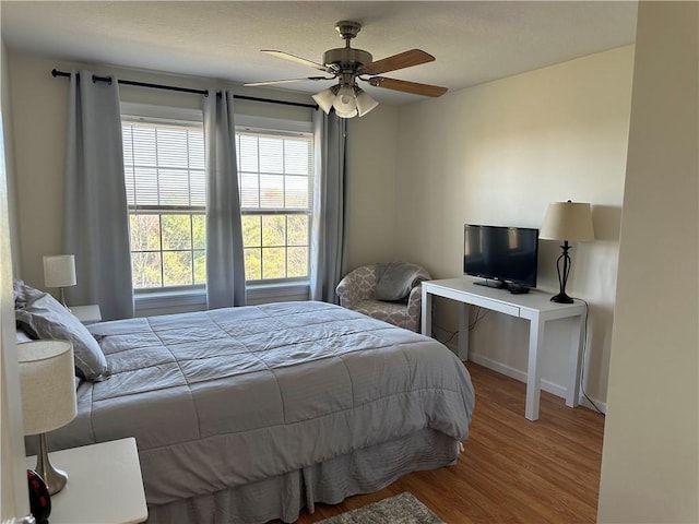 bedroom with ceiling fan and wood-type flooring