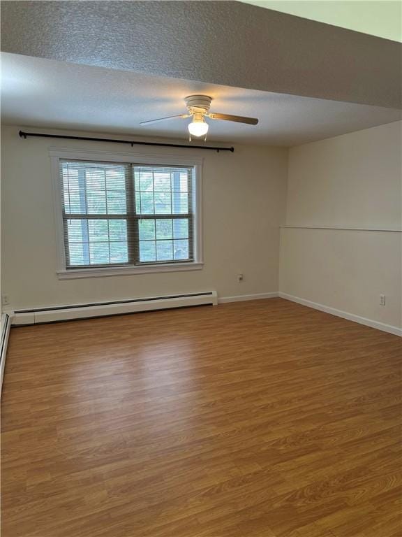 unfurnished room featuring baseboard heating, ceiling fan, and wood-type flooring