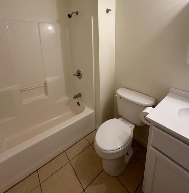 full bathroom with tile patterned floors, vanity, tub / shower combination, and toilet