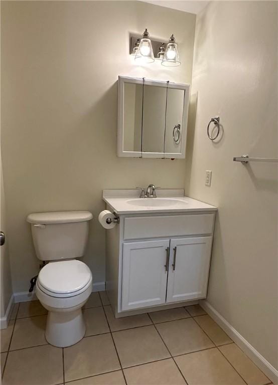 bathroom with toilet, vanity, and tile patterned floors