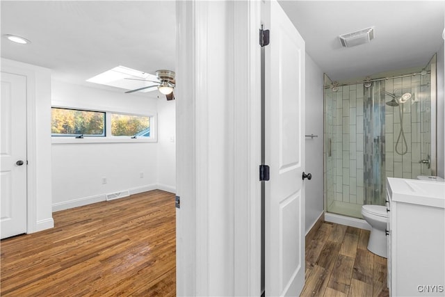 9869 Hazard Rd, Marcy, NY 13403 - full bath with ceiling fan, wood finished floors, a shower stall, a skylight, and toilet