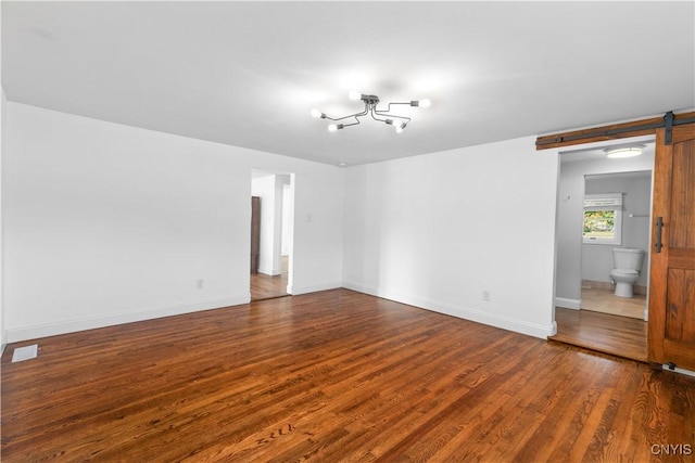9869 Hazard Rd, Marcy, NY 13403 - spare room with a barn door, dark wood-style flooring, a chandelier, and baseboards