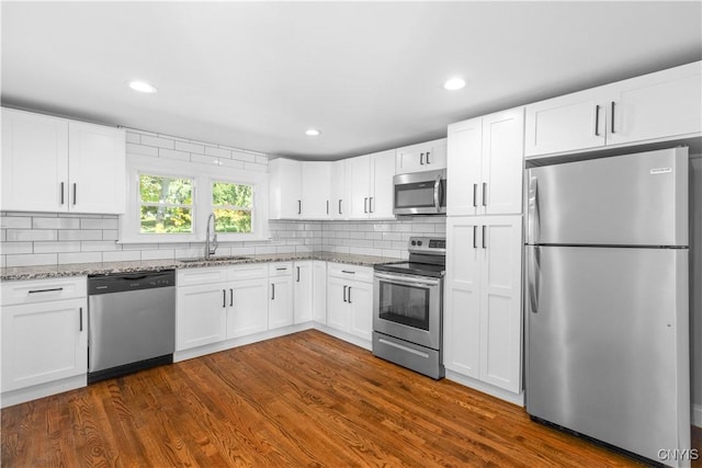 9869 Hazard Rd, Marcy, NY 13403 - kitchen with stainless steel appliances, a sink, light stone counters, white cabinetry, and backsplash