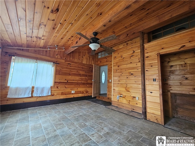 spare room with ceiling fan, wood walls, wooden ceiling, and vaulted ceiling