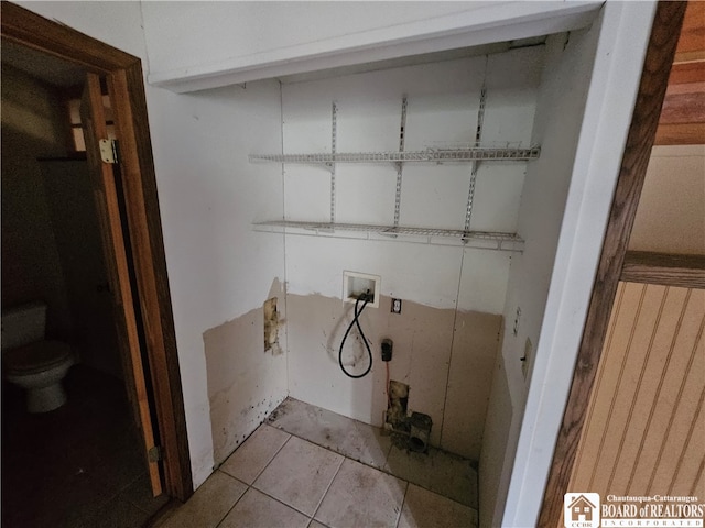 laundry area featuring hookup for a washing machine and light tile patterned floors