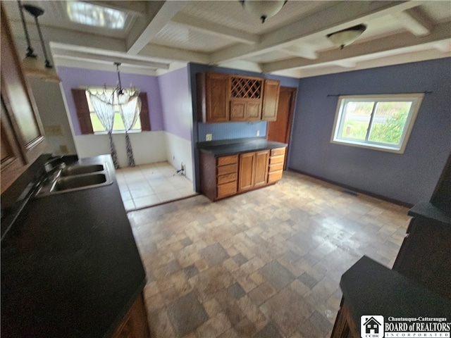 kitchen with beamed ceiling, an inviting chandelier, decorative light fixtures, and sink