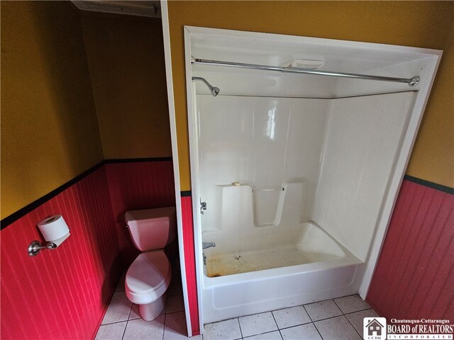 bathroom with toilet, bathing tub / shower combination, and tile patterned flooring