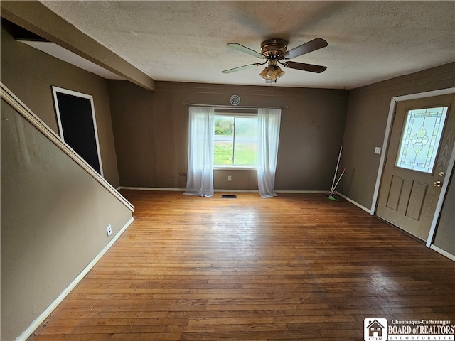 entrance foyer with hardwood / wood-style floors, a textured ceiling, and ceiling fan