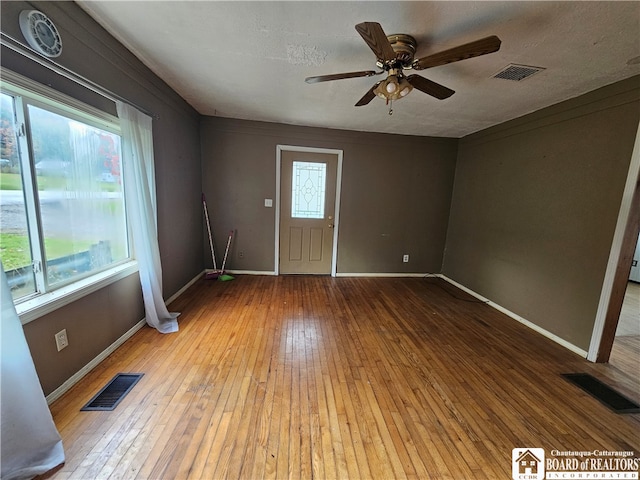 spare room with a textured ceiling, wood-type flooring, and ceiling fan