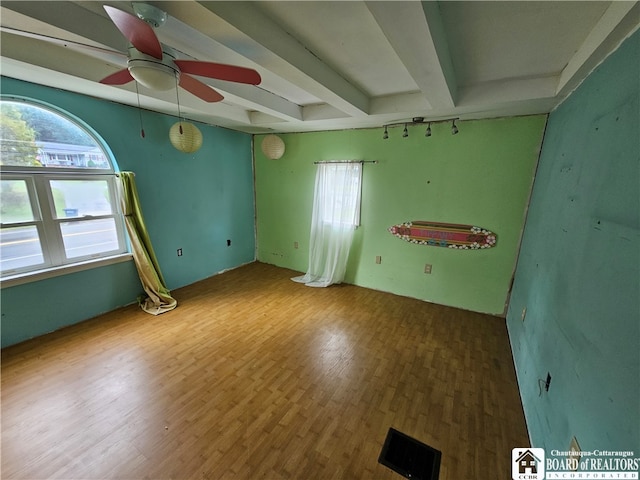 unfurnished room with ceiling fan, hardwood / wood-style flooring, and beamed ceiling