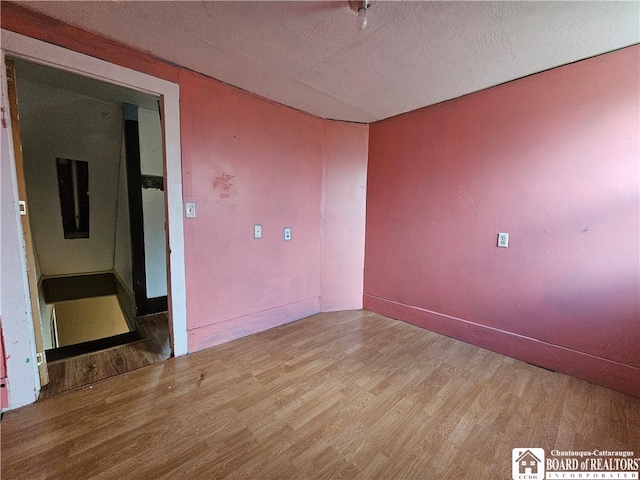 empty room with hardwood / wood-style floors and a textured ceiling