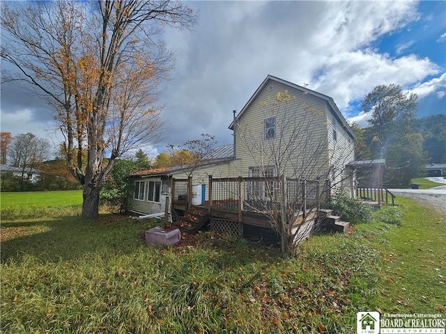 back of house with a wooden deck and a yard