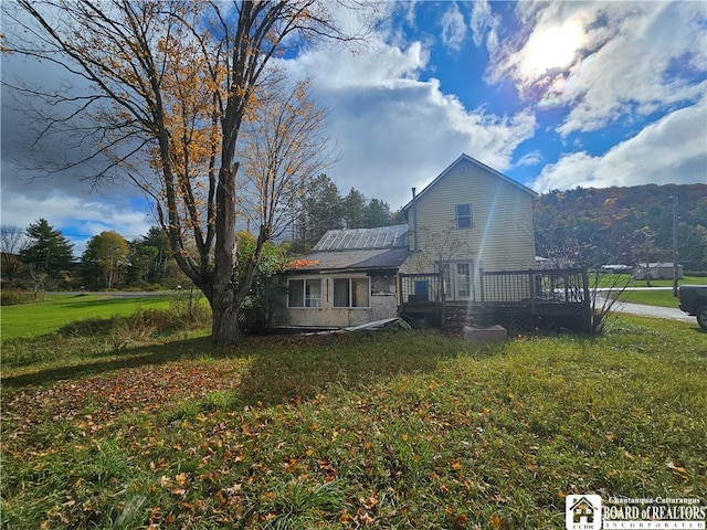 view of home's exterior with a yard and a wooden deck