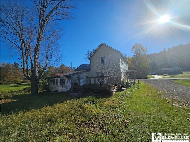 view of home's exterior with a yard and a deck