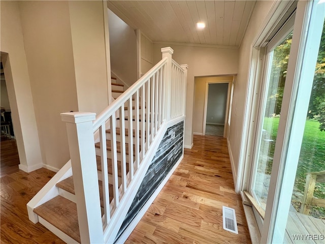 stairs with wood ceiling, vaulted ceiling, and hardwood / wood-style floors