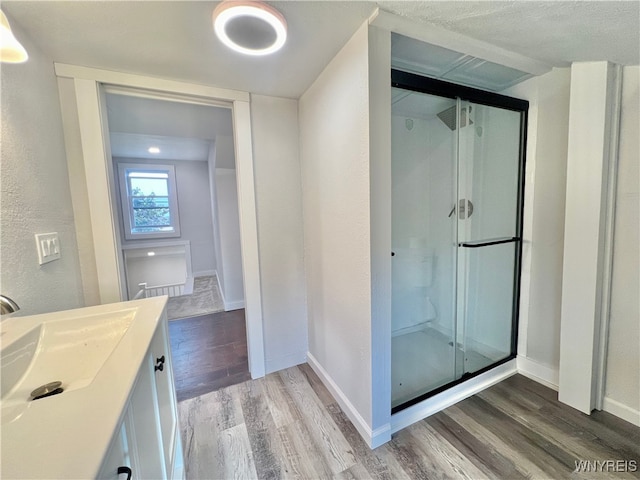 bathroom with vanity, hardwood / wood-style flooring, and a shower with shower door