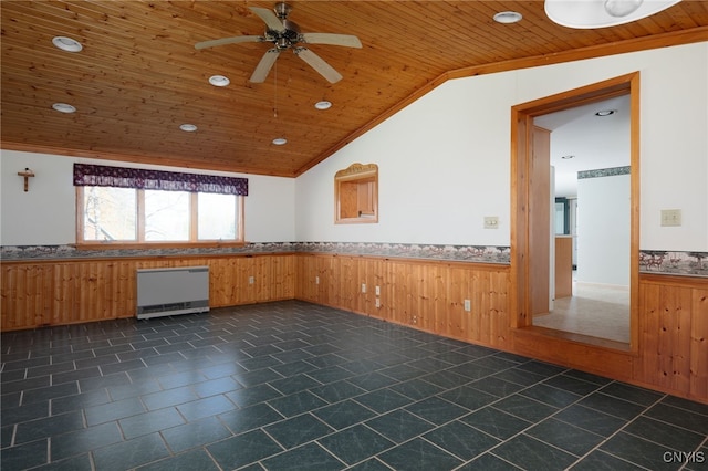 empty room featuring wood walls, vaulted ceiling, ceiling fan, and wooden ceiling