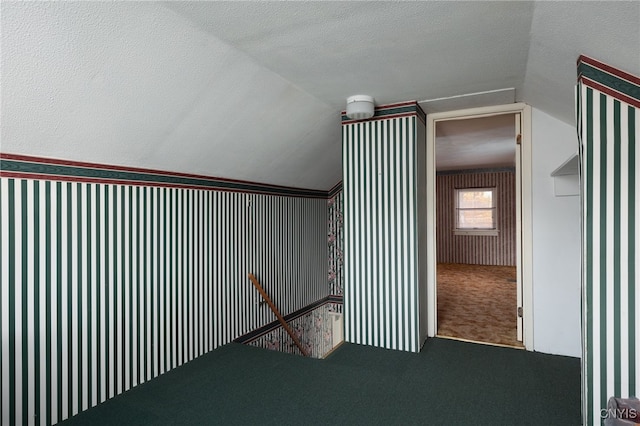 stairs with carpet, a textured ceiling, and vaulted ceiling