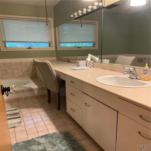 bathroom with vanity, a relaxing tiled tub, and tile patterned floors