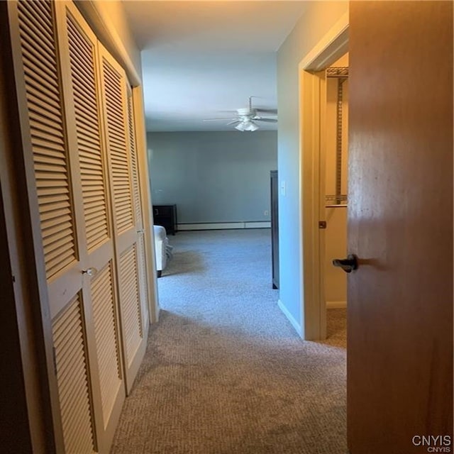 hall with a baseboard radiator and light carpet