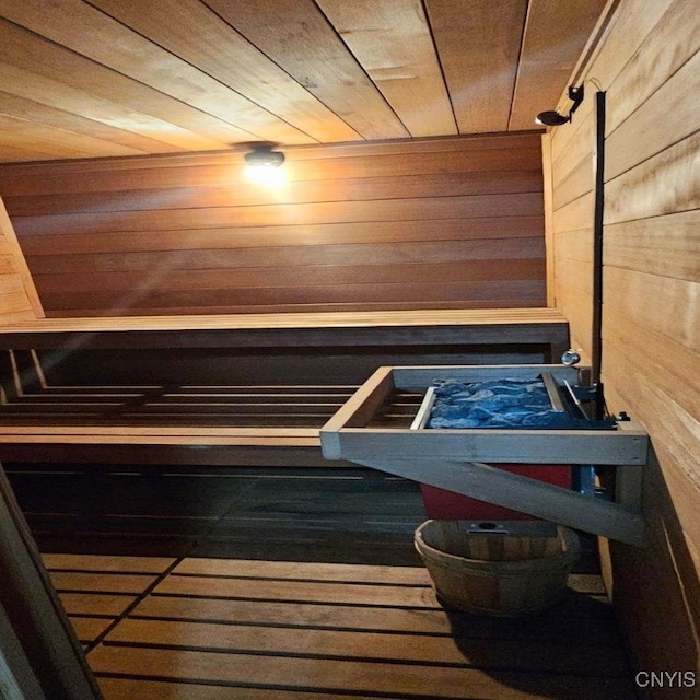 view of sauna / steam room with wooden walls, wood-type flooring, and wooden ceiling