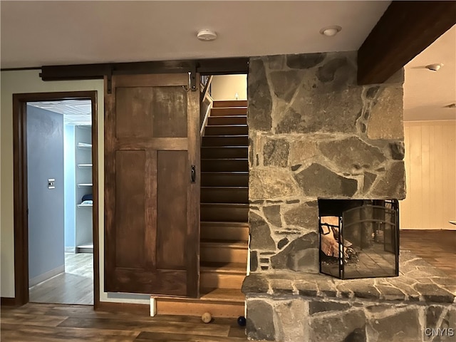 details with a barn door, a fireplace, and wood-type flooring