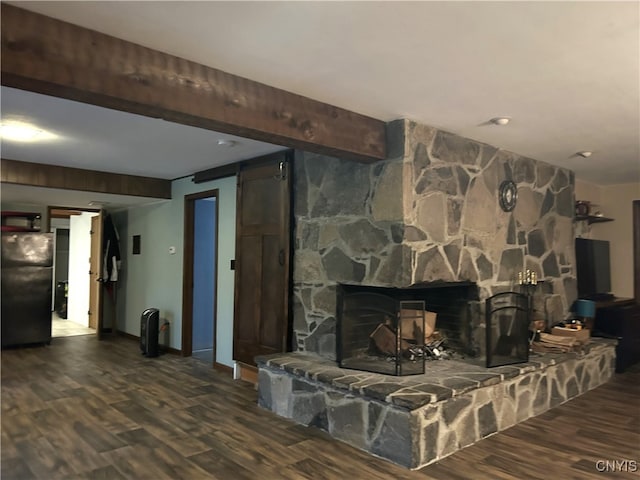 living room featuring a barn door, dark wood-type flooring, and a fireplace