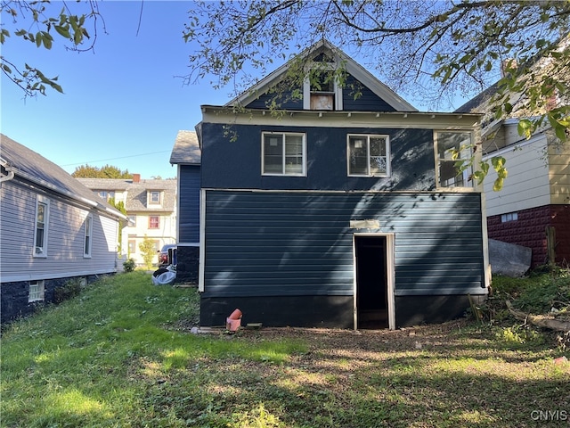 rear view of house featuring a lawn