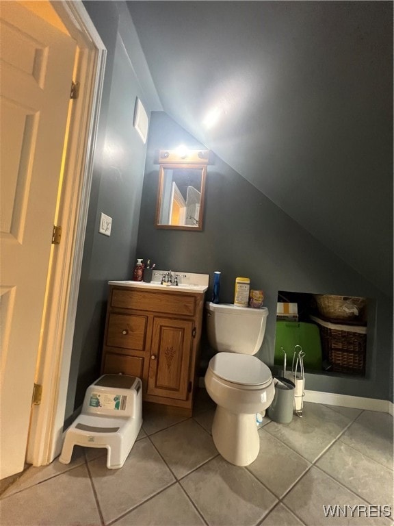 bathroom with vanity, toilet, tile patterned floors, and vaulted ceiling