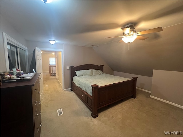 bedroom with ceiling fan, light carpet, and lofted ceiling