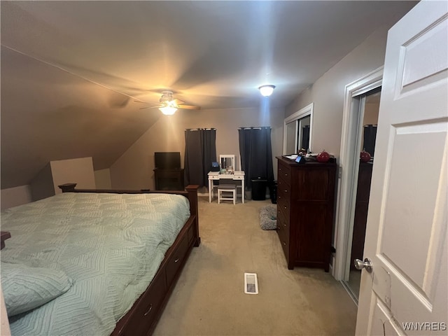 carpeted bedroom with a closet, lofted ceiling, and ceiling fan