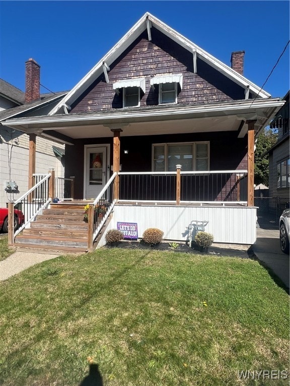 view of front of property featuring covered porch and a front yard