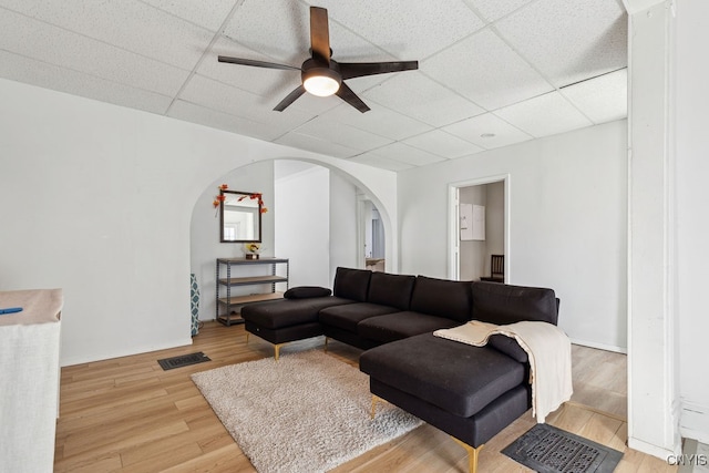 living room with light hardwood / wood-style flooring, a paneled ceiling, and ceiling fan