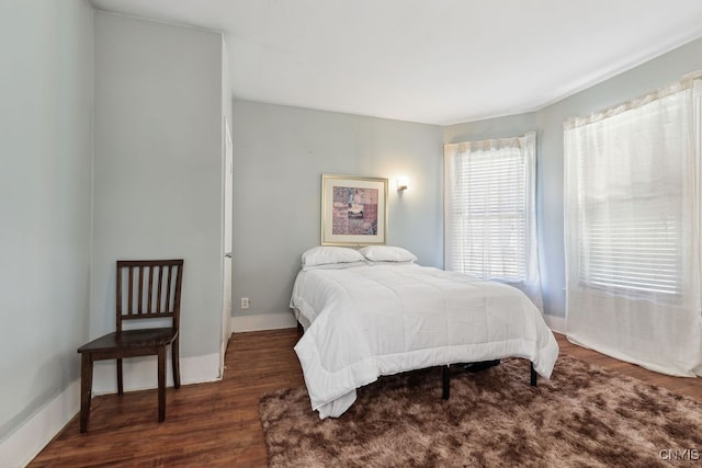 bedroom with dark hardwood / wood-style floors