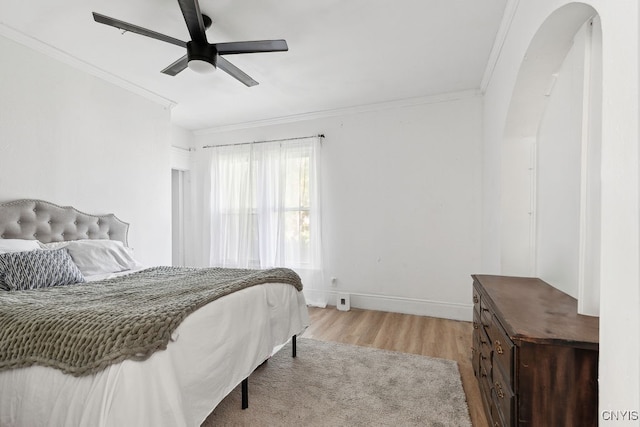 bedroom with crown molding, light hardwood / wood-style flooring, and ceiling fan