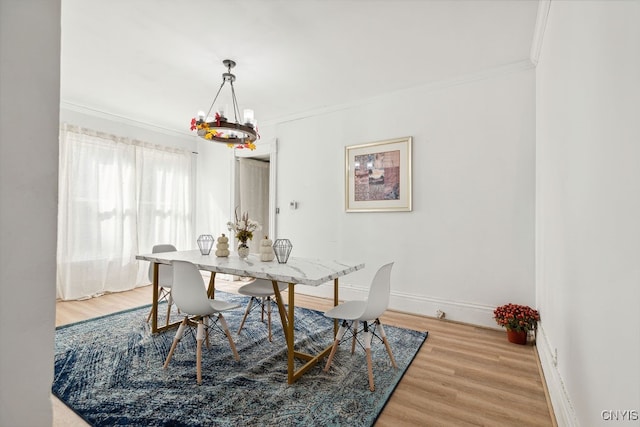 dining space with crown molding, a notable chandelier, and hardwood / wood-style floors