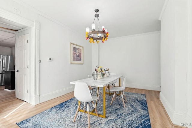 dining room with ornamental molding, a chandelier, and hardwood / wood-style flooring