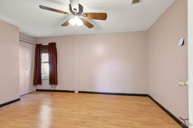 spare room with light wood-type flooring and ceiling fan