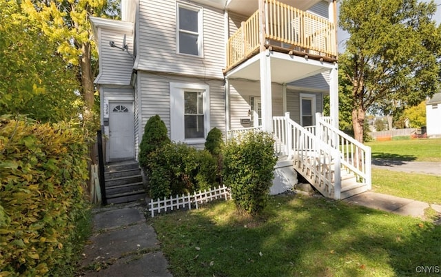 view of front of property with a balcony and a front lawn