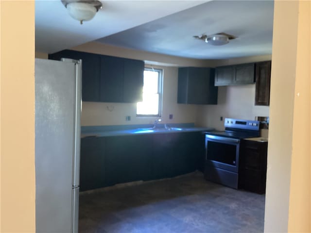 kitchen with stainless steel electric stove, sink, and white refrigerator