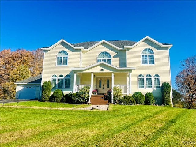 view of front facade with a porch, a front lawn, and a garage