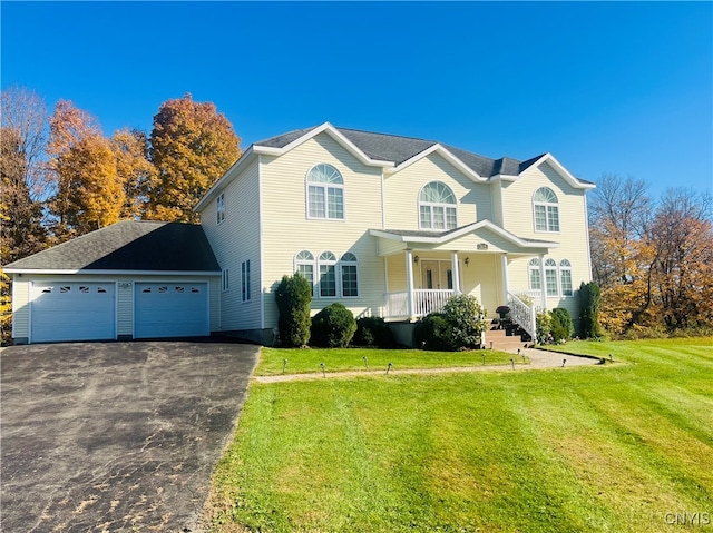 front of property with a front yard, covered porch, and a garage