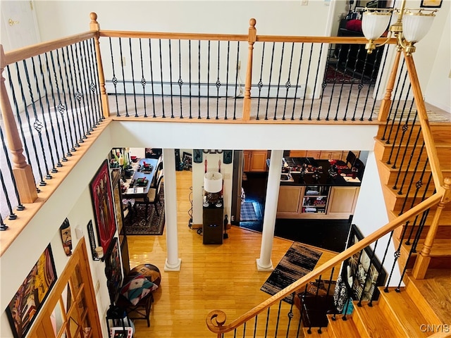 stairway featuring hardwood / wood-style flooring and ornate columns