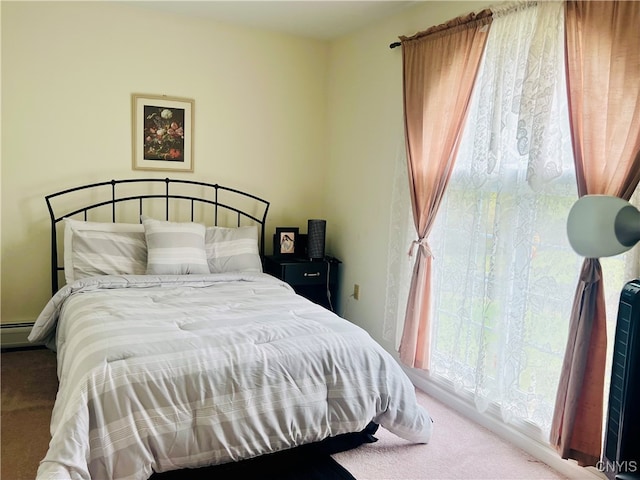 bedroom with a baseboard heating unit and carpet flooring