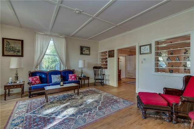 living area with coffered ceiling, wood finished floors, and baseboards