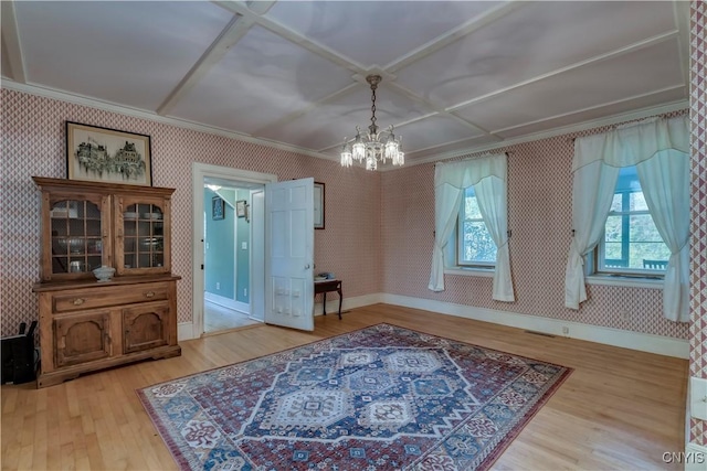 dining room featuring ornamental molding, an inviting chandelier, wood finished floors, and wallpapered walls