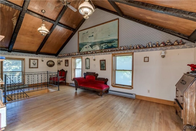 living area featuring beam ceiling, plenty of natural light, an upstairs landing, and wood finished floors