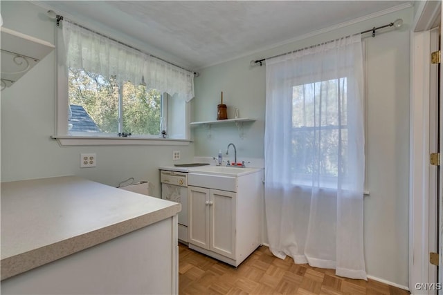 kitchen featuring open shelves, light countertops, white cabinetry, white dishwasher, and a sink