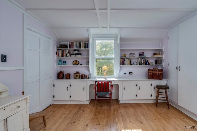 interior space with light wood finished floors, built in features, and beam ceiling